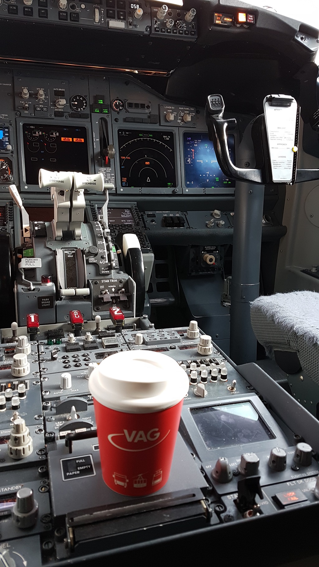 VAG-Cup., stabilen Mehrwegbecher im VAG-Design, im Cockpit eines Flugzeuges